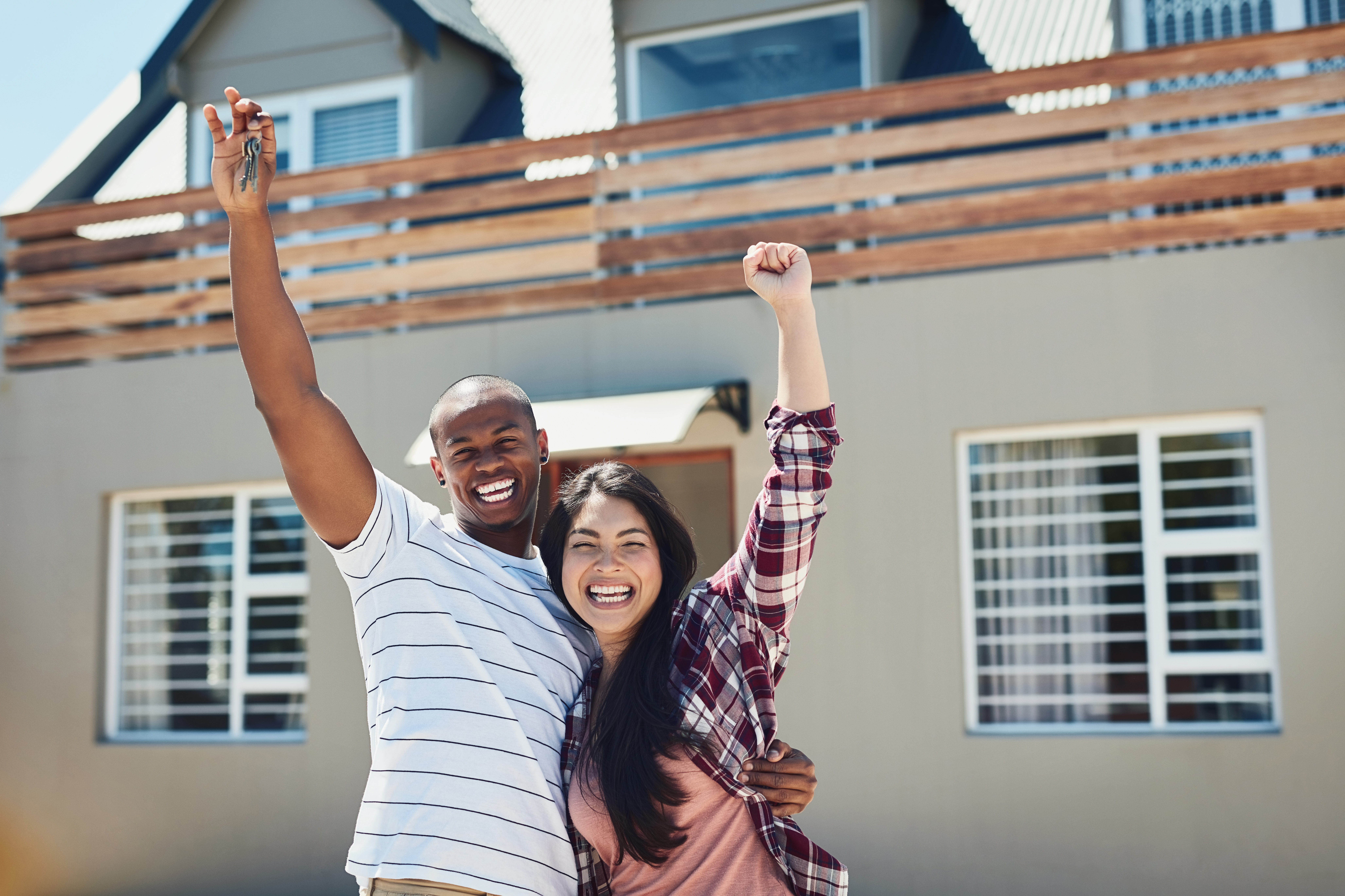 young couple holding the keys to their new home