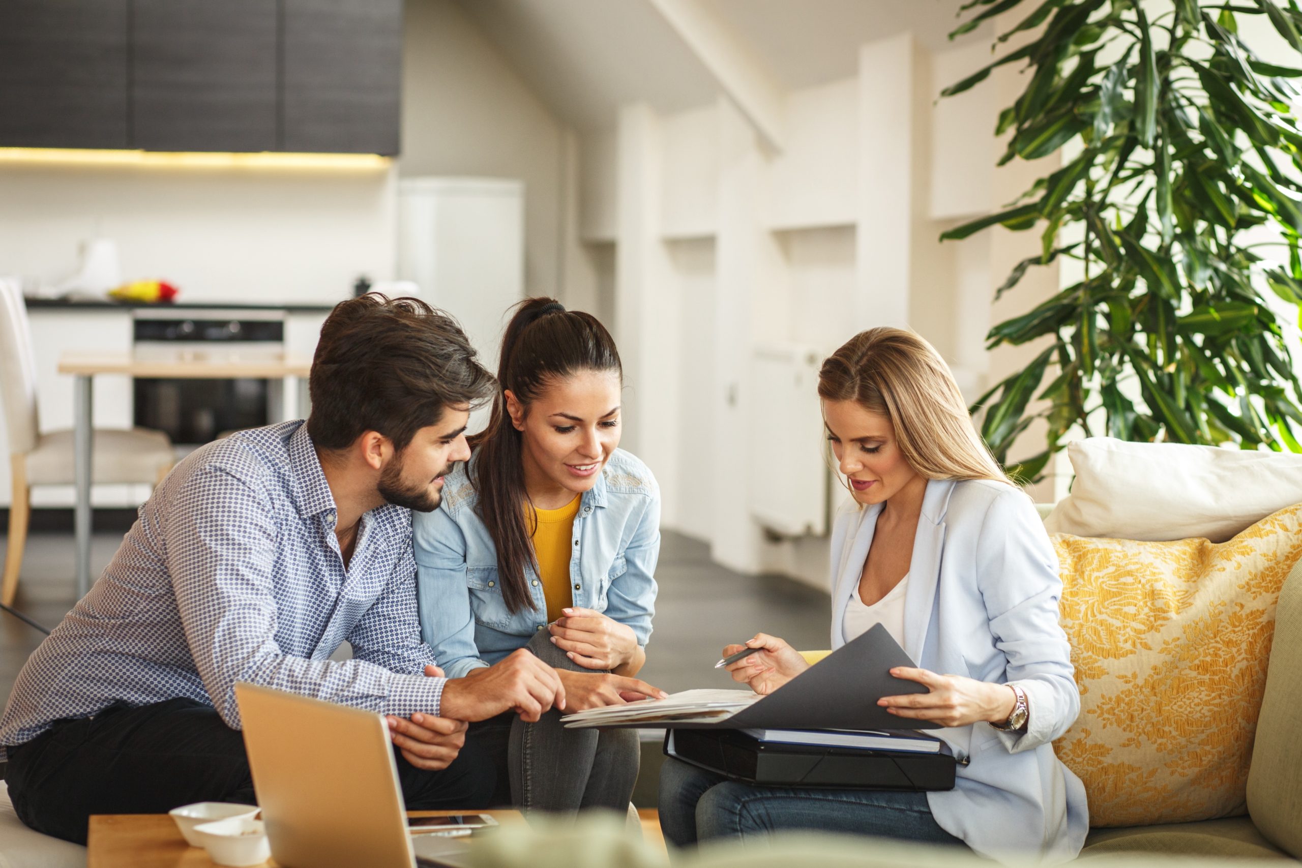 Female Real Estate agent working with young couple.
