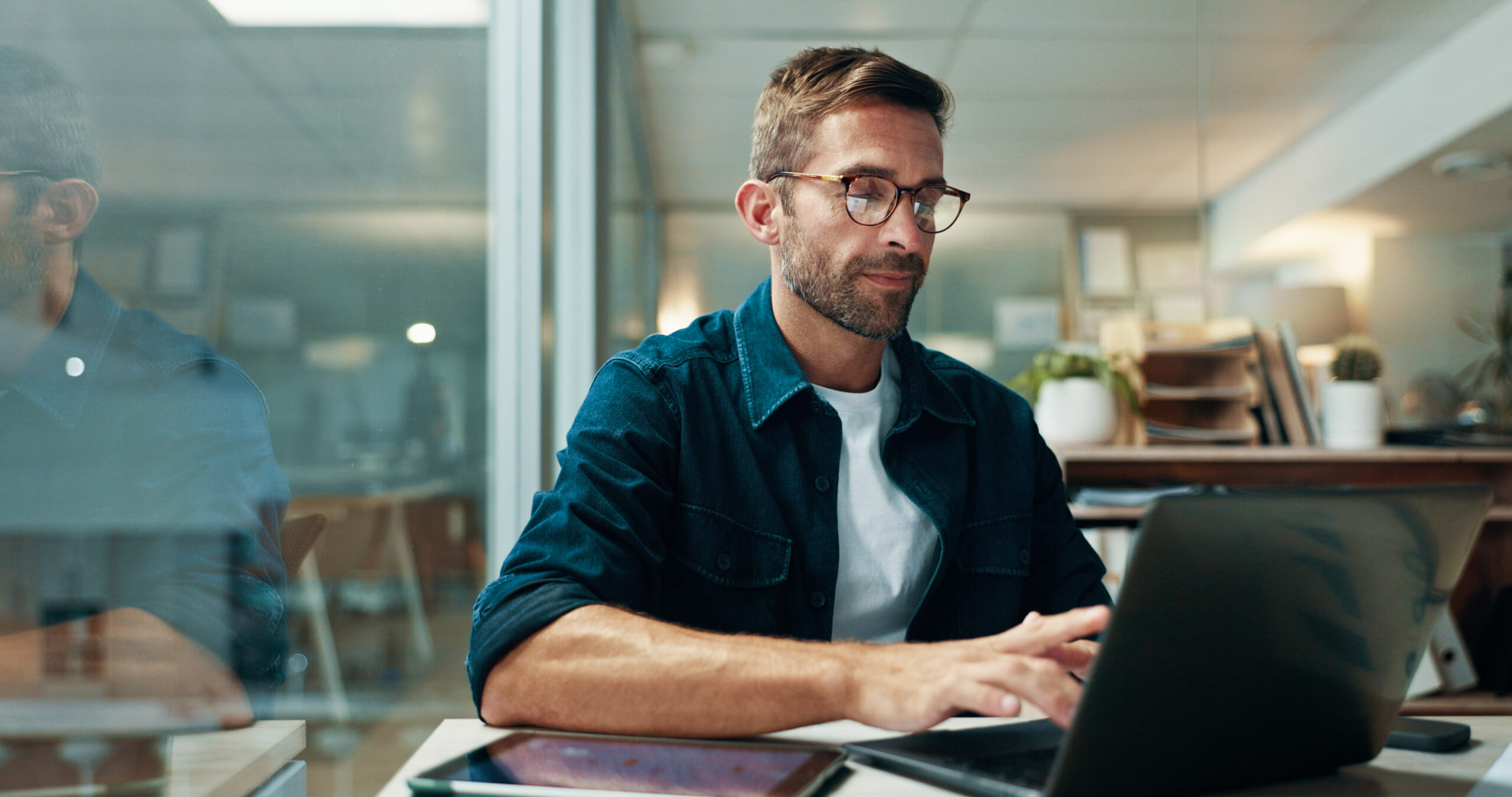 Male real estate agent working on laptop as desk